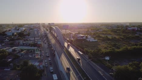 aerial - arch over freeway at sunset in reynosa, mexico, wide rising shot