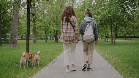 two women walking their dog in a park