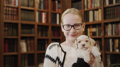 happy child in the library are a girl and a puppy with glasses. cute pets and education