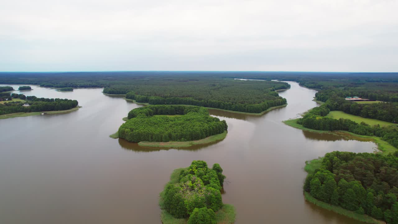 Drone over peaceful forest lake in Polish lakeland