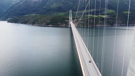 descending aerial close to concrete column at hardanger suspension bridge - panoramic view over one of worlds biggest suspension bridges - hardanger norway