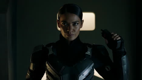 intense woman in tactical gear holding a device