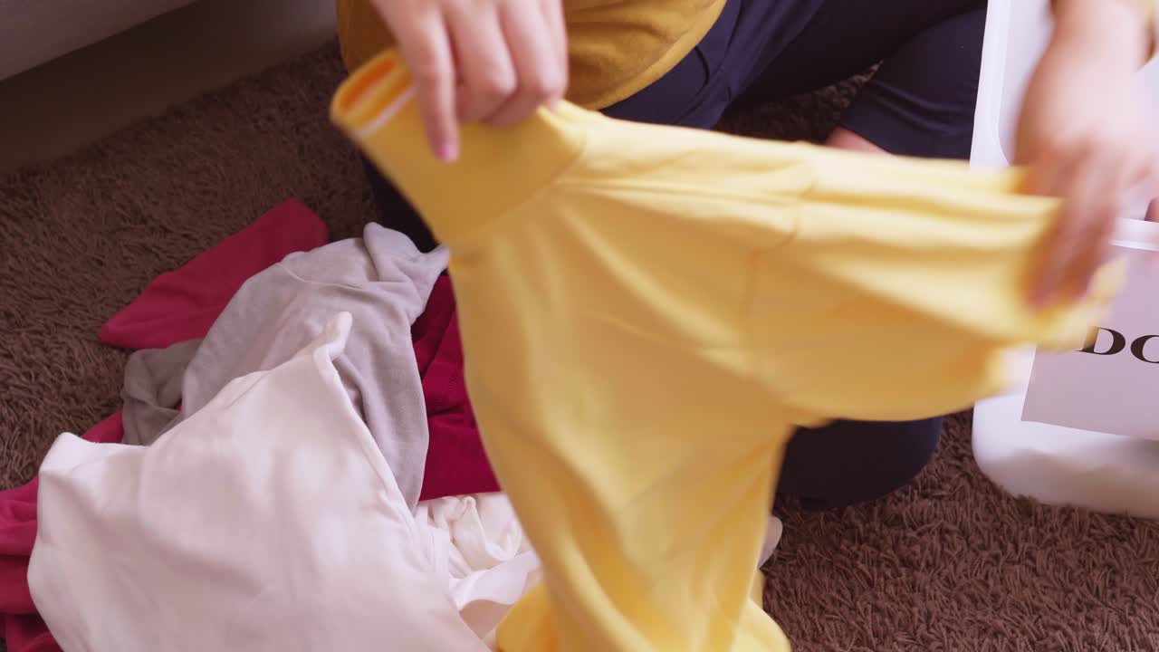 기부를 위해 옷을 접는 여성 손의 세부 사항