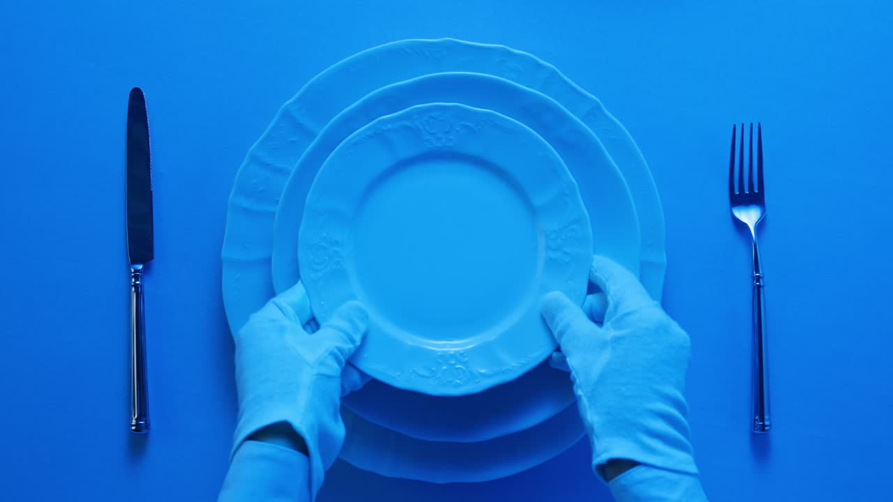 Elegant table setting with white tableware plates, cutlery, and glassware for a classy dining, fancy expensive restaurant dinner