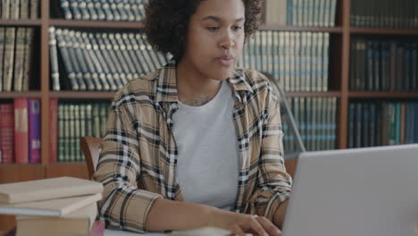 una mujer joven estudiando en una biblioteca.