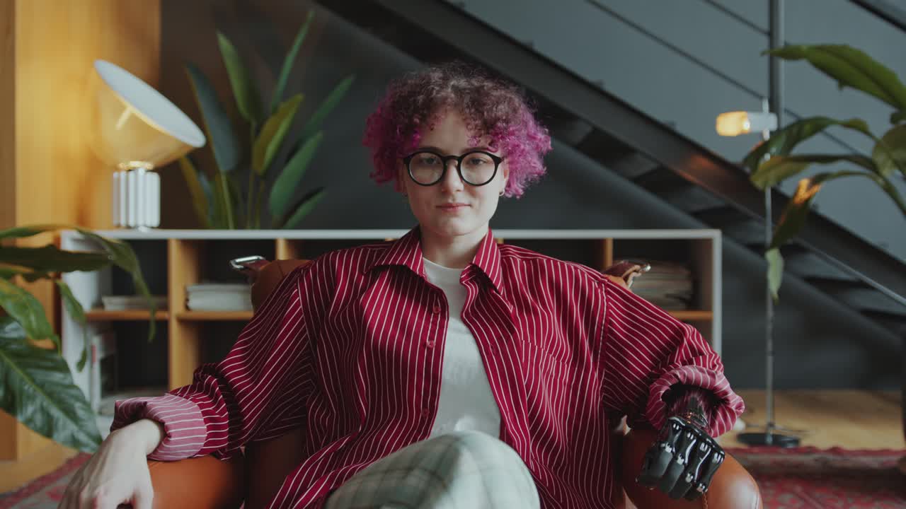 Portrait of Young Businesswoman with Prosthetic Arm Sitting in Armchair