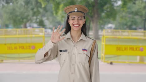 Happy-Indian-female-police-officer-waving-hello