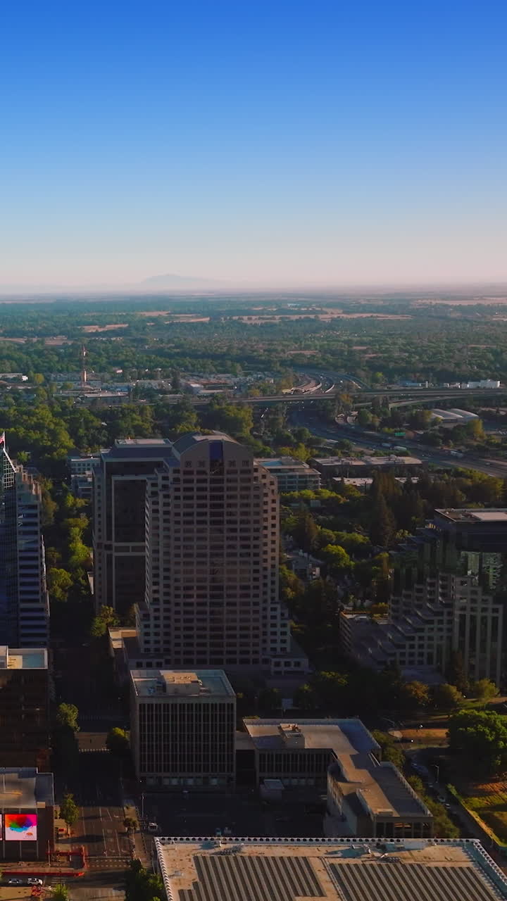 Rising over the beautiful capital of California State on bright sunny day. Modern buildings of Sacramento at the backdrop of clear blue sky. Vertical video