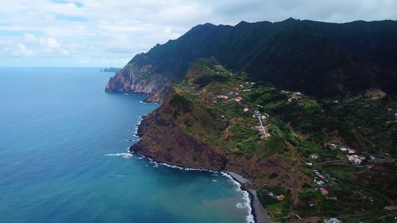 Scatto paesaggistico aereo di colline ripide e della costa dell'Oceano Atlantico a Madeira, Portogallo.
