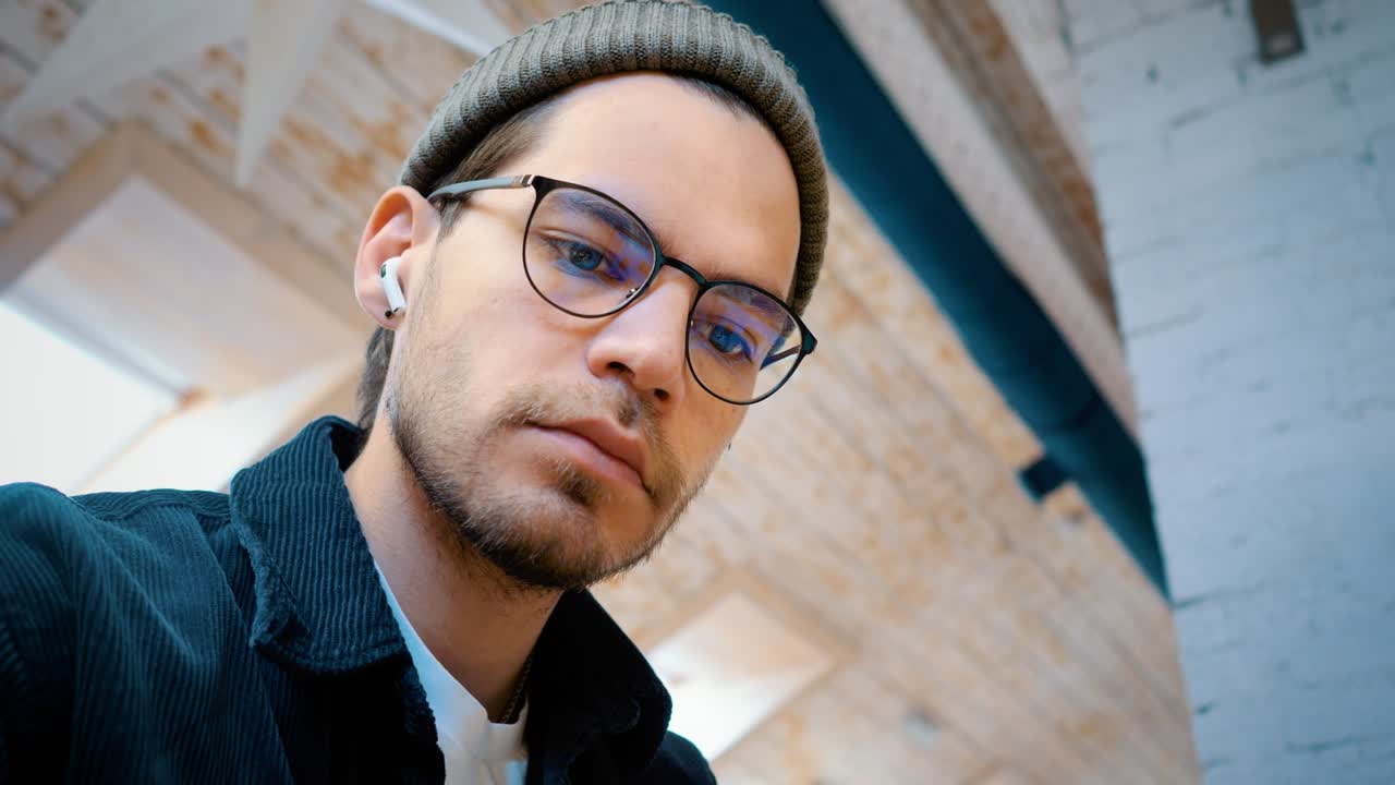 un programador o freelancer con gafas trabaja en una computadora portátil. escribe en un bloc de notas. primer plano de una cara