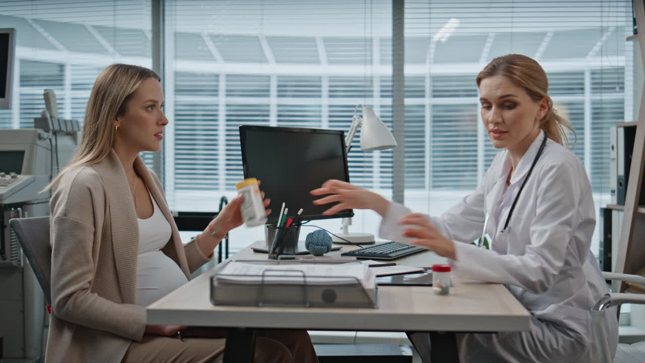 Gynecologist giving patient vitamins pills during medical appointment in clinic