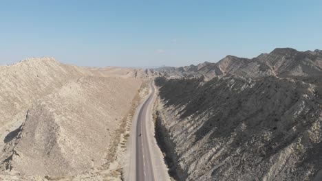 aerial view of makran coastal highway road beside dramatic rock formations in hingol national park