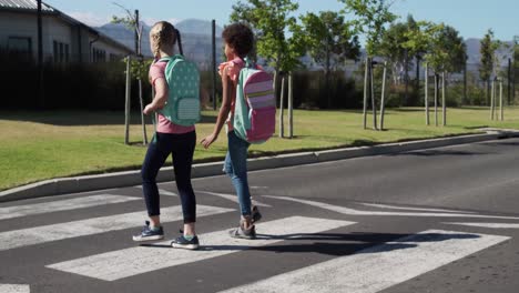 Two-girls-with-school-bags-crossing-the-road