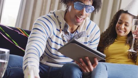 video of happy diverse couple celebrating new years eve and making video call on tablet at home