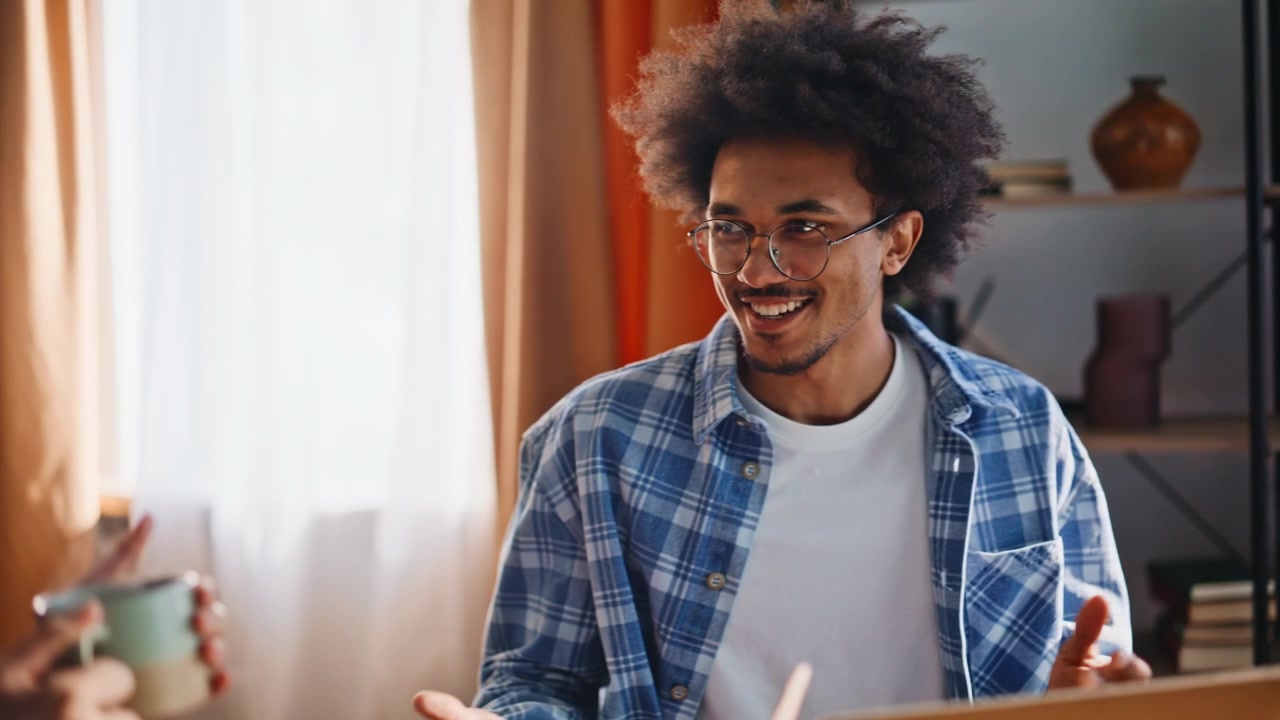 Multiracial couple chatting over morning coffee. Closeup of friends at home