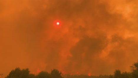 Standing-on-a-highland-road,-looking-at-the-red-sun,in-middle-of-dangerous-wildfire-smoke---POV-shot