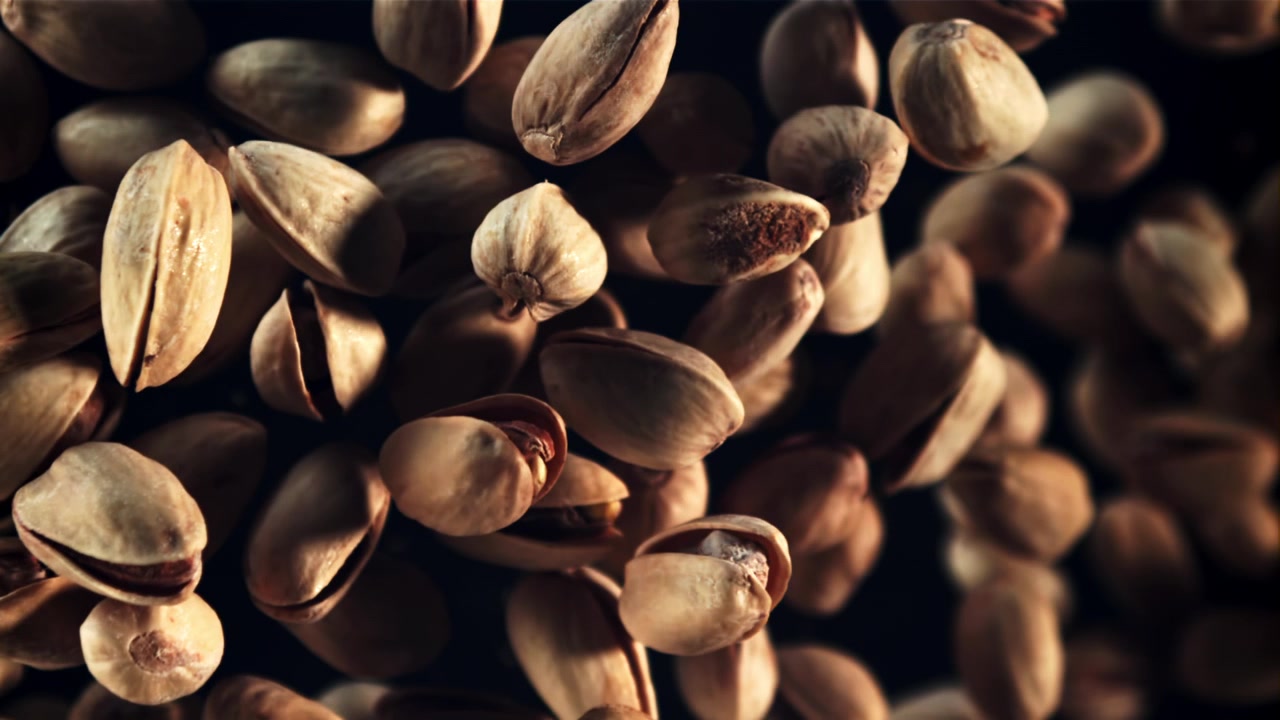 Slow Motion Shot of Pistachios Falling on Black Background