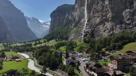 aerial - lauterbrunnen village with cascading waterfalls and towering cliffs in bernese alps, switzerland