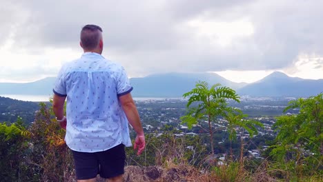 man walking in from behind camera to enjoy the view at a lookout, slow motion still shot,