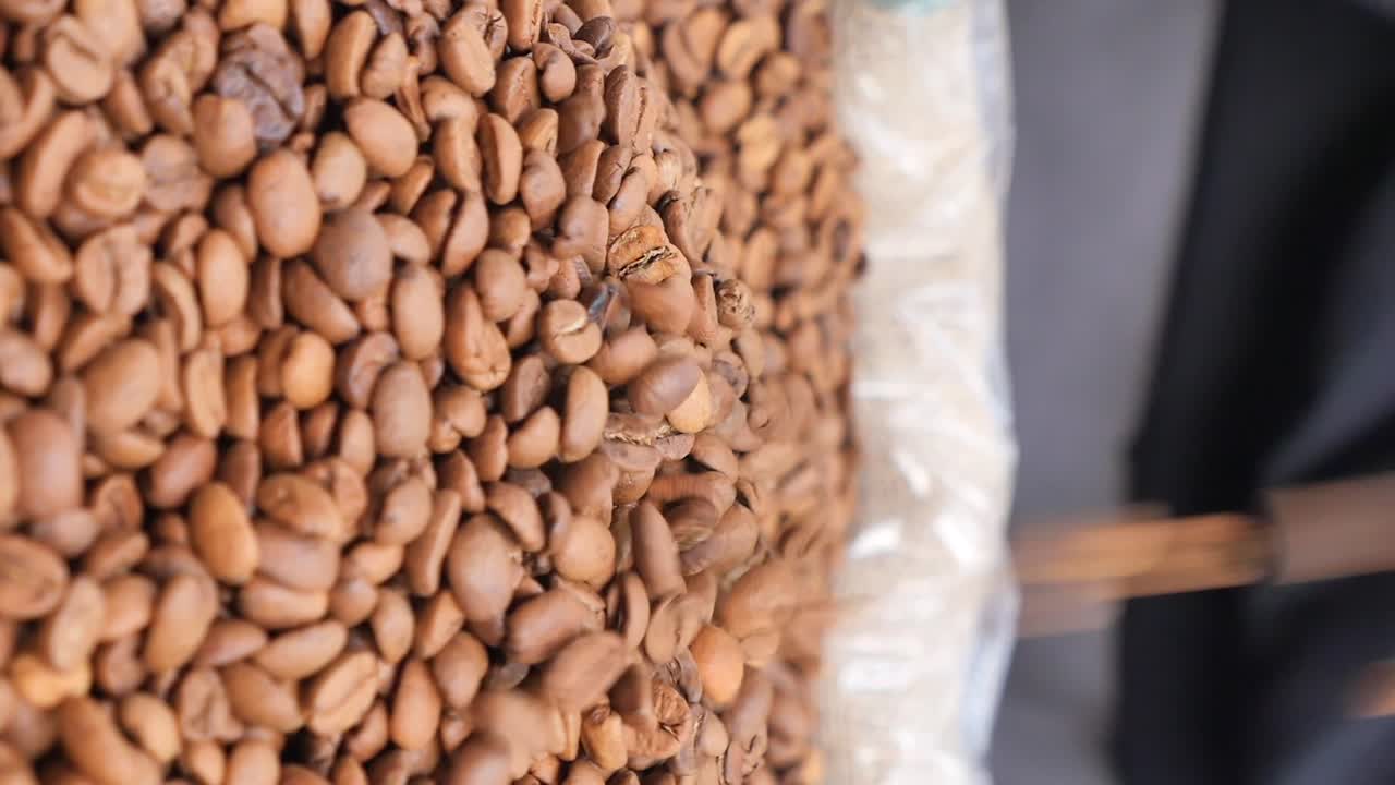 Grãos de café torrados sendo despejados em close-up