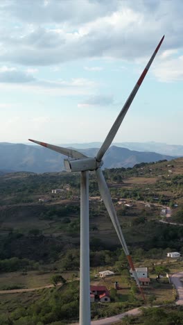 windmill on mountain ridge under dramatic sky, renewable energy for greener planet