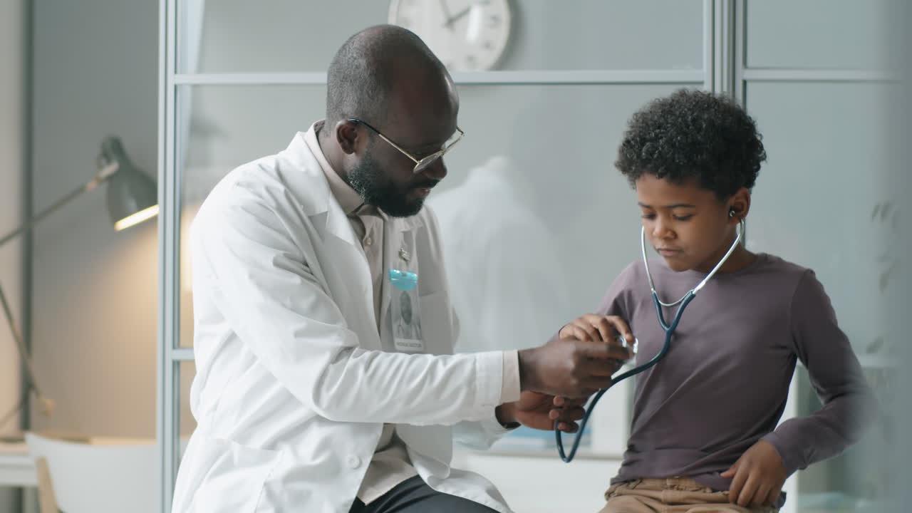 Little African American Boy Playing with Stethoscope at Doctors Office