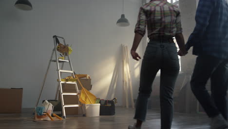 Pareja-Alegre-Disfrutando-Del-Nuevo-Diseño-De-La-Casa-En-El-Interior.-Mujer-Mirando-Alrededor-Del-Apartamento.