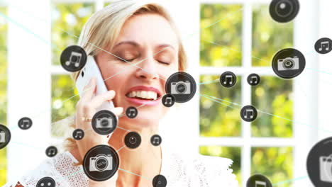 Animation-of-network-of-connected-icons-in-circles-over-happy-caucasian-woman-using-smartphone