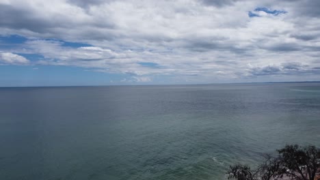 Drone-ascending-from-a-park-to-reveal-the-ocean-at-dawn