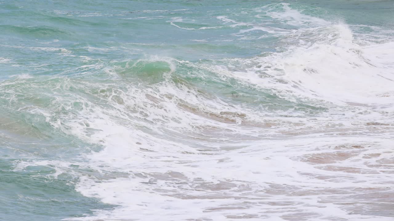 Dynamic ocean waves crash against the shore at Port Campbell, captured in bright daylight with a focus on natural movement