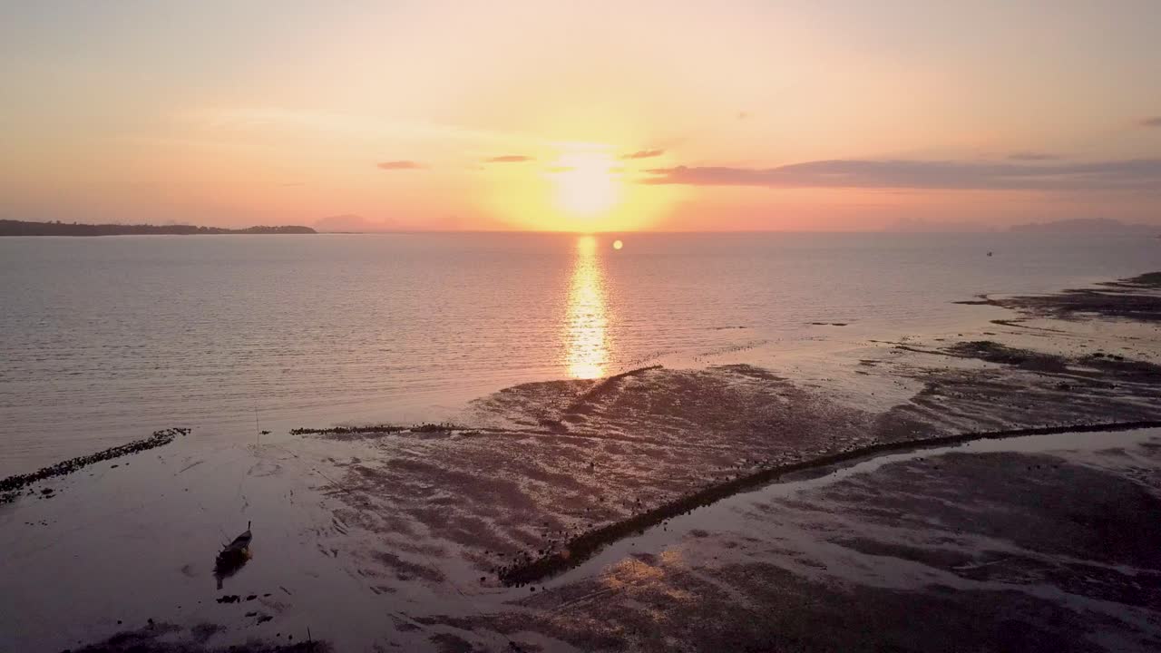 вид с воздуха на красивый океанский закат в таиланде - слежение за камерой над водой во время отлива