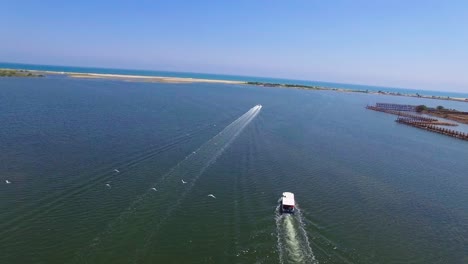 disparo de drones volando a través de la boca del canal de remanso con dos botes, un bote de pasajeros y un bote de velocidad cruzando el marco