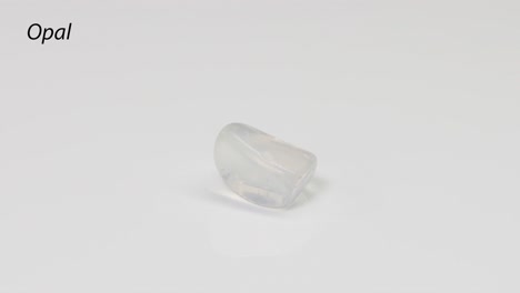 piedra preciosa de ópalo giratoria en una superficie blanca