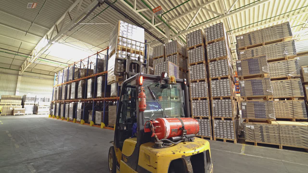 Empilhadeira entre os materiais no hangar. Armazenamento de pisos e parquet.