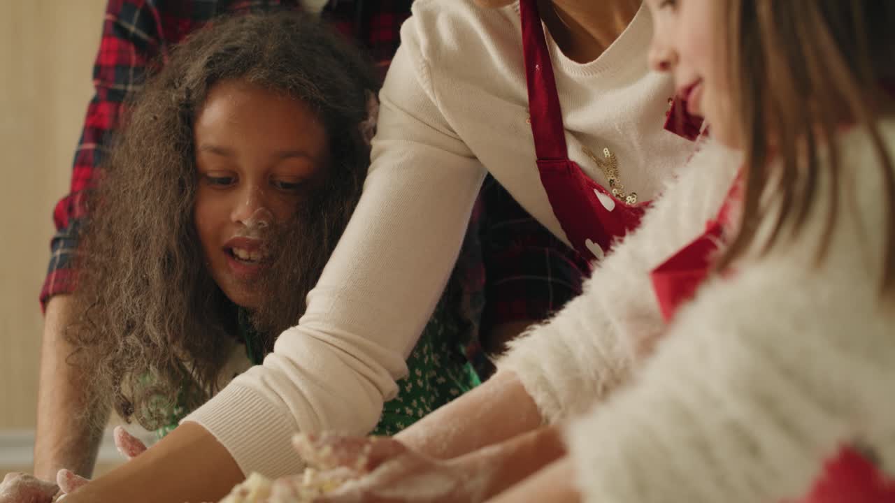 vista inclinada hacia abajo de la familia haciendo masa en la cocina