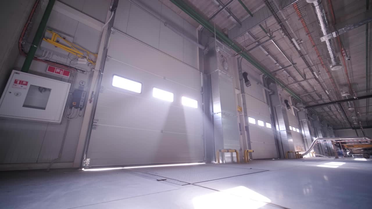 proceso de construcción de un gran almacén moderno con múltiples puertas de garaje para un fácil acceso y transporte de mercancías.