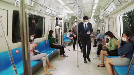 multitud de personas con máscaras faciales en un tren de metro público lleno de gente