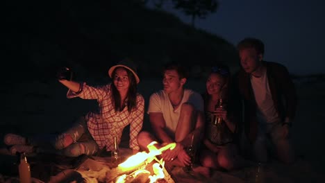 picnic de jóvenes con fogata en la playa por la noche 4