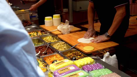 hands of chinese man making street food with multiple ingredients