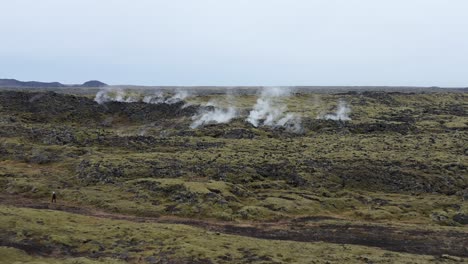 el vapor se eleva desde los géiseres islandeses en un terreno geotérmico salvaje, aéreo