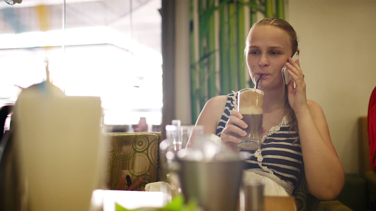 una mujer en un café hablando por teléfono.