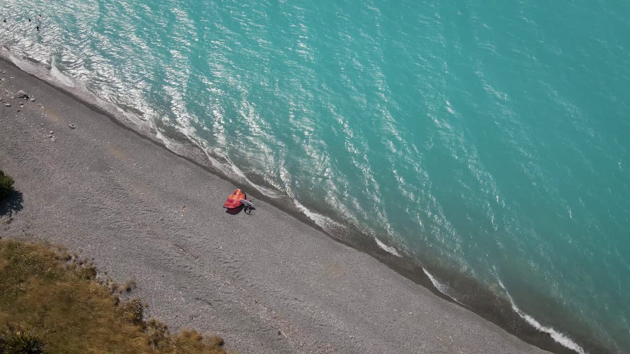 Top down aerial view of wing foil surfing gear on lakeshore - blue lake water