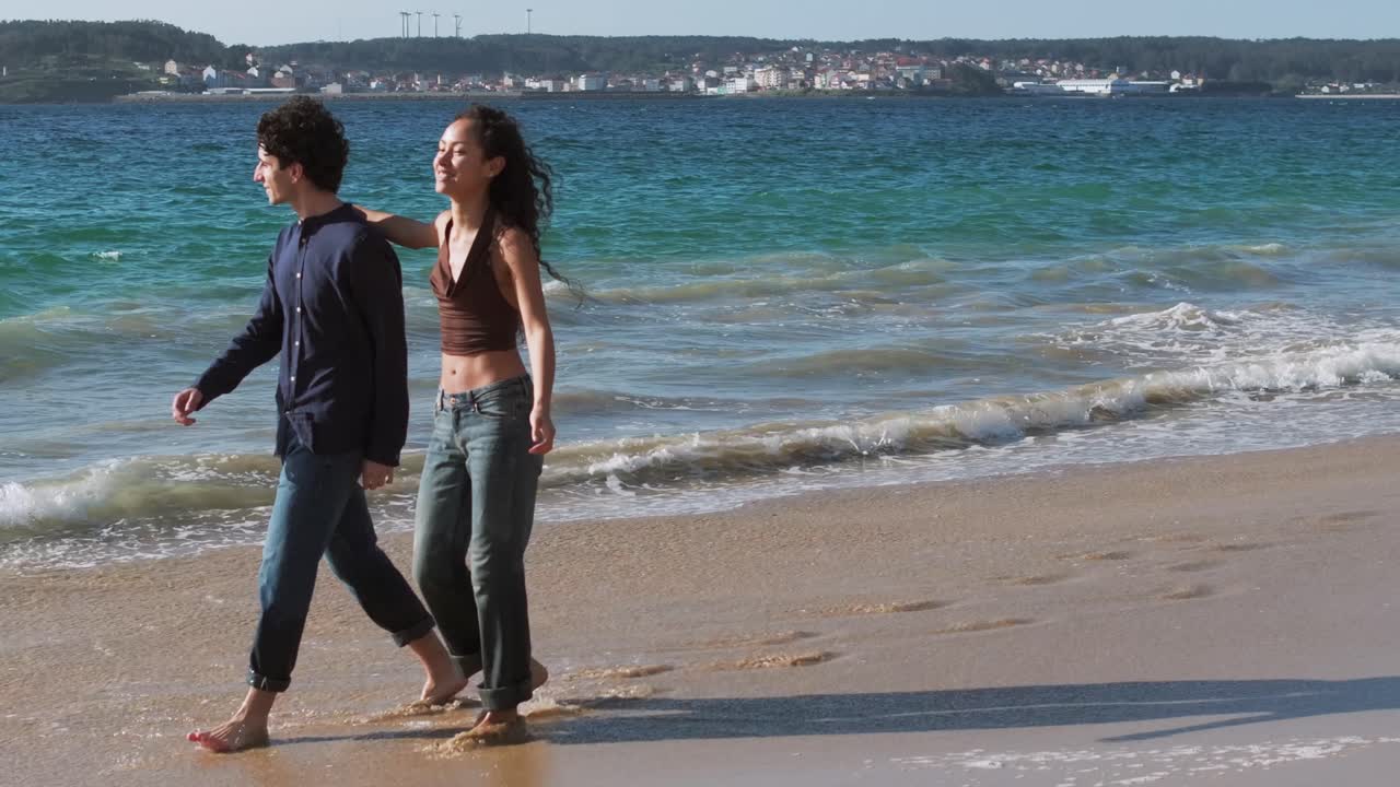 In love Young Couple Embracing, Holding Hands And Walking At The Beach In Summer. - aerial shot