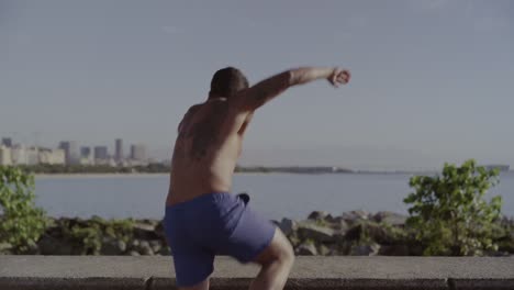 man exercising plank by the waterfront