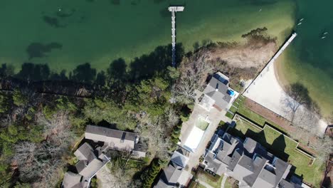 coastal luxury estate with small pier in america, aerial top down view