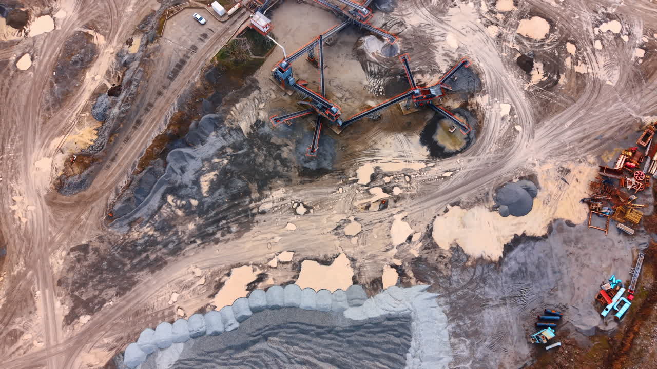 Aerial view of gravel production plant. Detailed top down view of conveyor belts and piles of crushed stone in a quarry