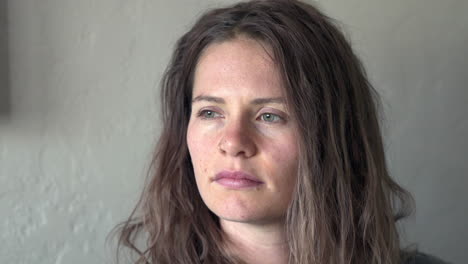 a woman gazes stoically into the distance, her expression serene yet contemplative. the camera slowly moves around her, capturing her emotions and surroundings.