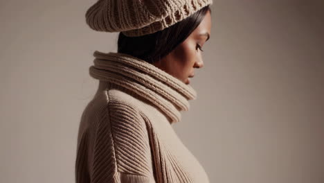 close-up profile of a woman in beige knitted winter fashion