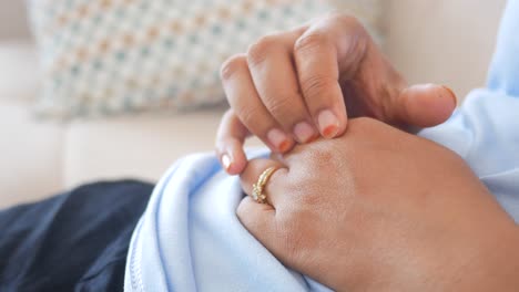 una mujer embarazada sentada en un sofá con la mano en el vientre.
