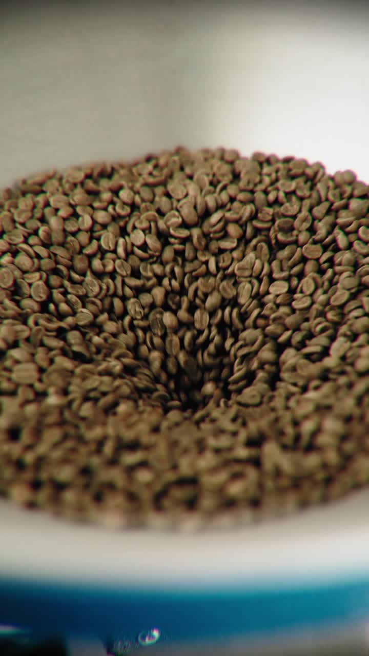 Fresh Unroasted Green Beans Falling Into a Container